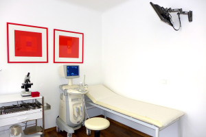 Geräte, Liegebett in einer Frauenarzt-Ordination und ein Monitor an der Wand