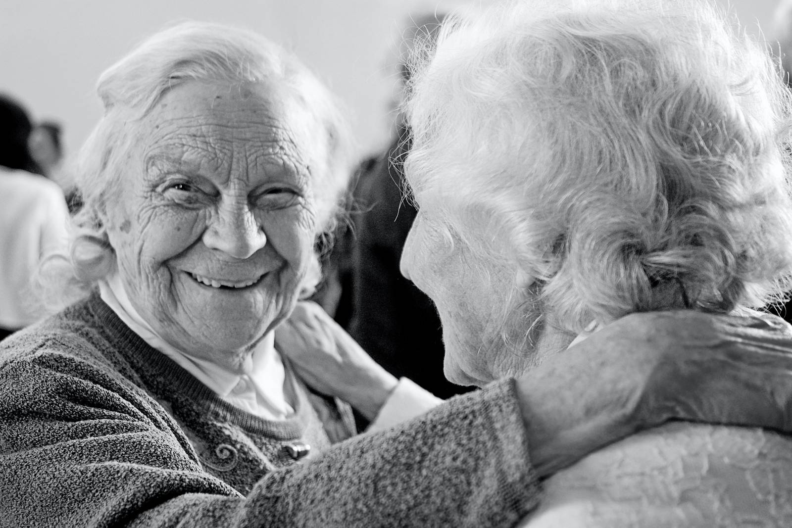 2 Seniorinnen in schwarz weiß eine lächelnd